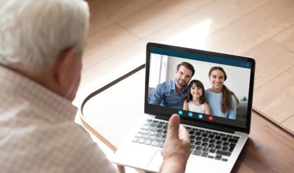 Man Using Computer with Family On Screen