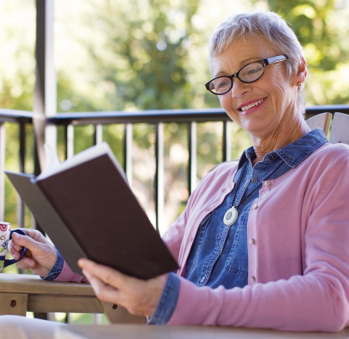 woman in sweater wearing HomeSafe reading book
