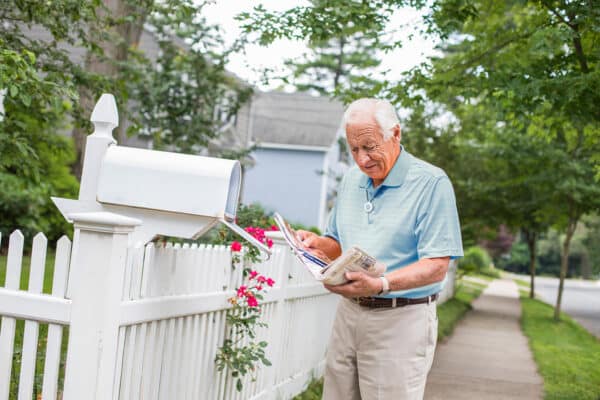 Man at mailbox wearing HomeSafe pendant